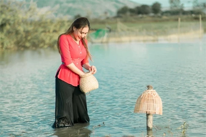 Nữ diễn viên thích thú khi vừa bắt được một con cá và bỏ ngay vào giỏ.