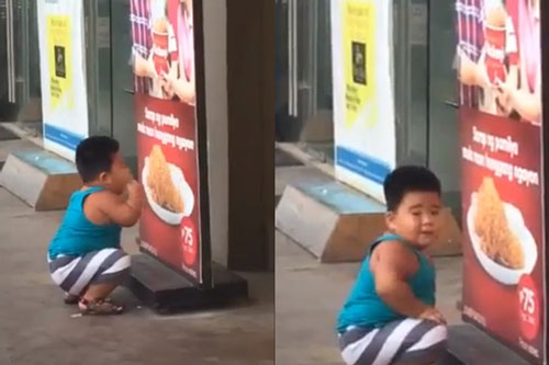 Thích ăn gà rán mà mẹ không cho, bé trai ngồi trước tấm biển ở cửa hàng và làm điều cực đáng yêu
