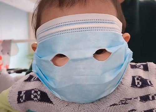 Em bé đeo chiếc khẩu trang có thiết kế lạ làm ai cũng chú ý nhưng lý do mới bất ngờ