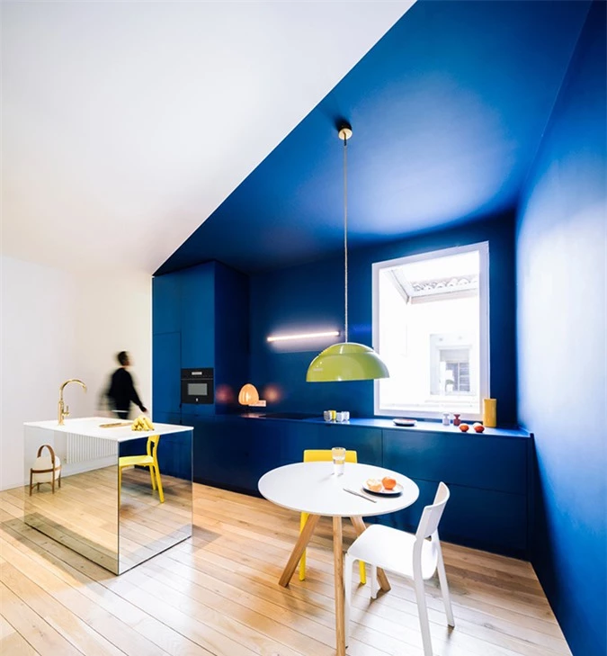 Phòng bếp được sơn gam xanh dương. Tường được chia mảng, sơn theo khối đa giác, tạo sự mới lạ.