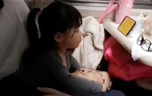Thấy bố mệt mỏi khi đi tàu, bé gái giúp trông hành lý rồi làm hành động được bao người khen ngợi