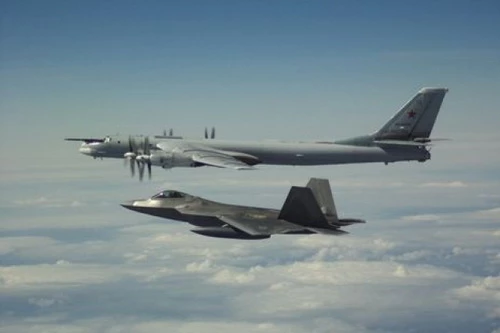 Tiêm kích tàng hình F-22A Raptor của Mỹ bay kèm máy bay ném bom chiến lược Tu-95MS của Nga. Ảnh: Avia-pro.