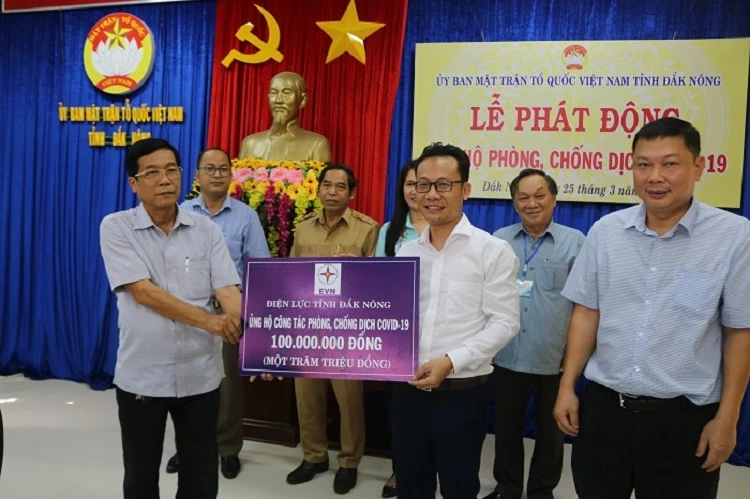 Ông Nguyễn Ngọc Ánh, Giám đốc Công ty Điện lực Đắk Nông (áo trắng) trao tặng 100 triệu đồng để đóng góp nguồn lực cùng địa phương và cả nước phòng, chống dịch Covid-19