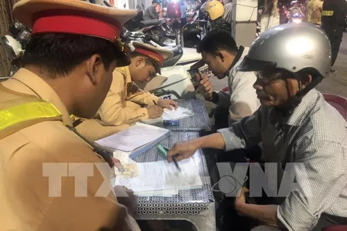 Lực lượng CSGT Công an tỉnh Bình Định lập biên bản các trường hợp lái xe vi phạm nồng độ cồn. (Ảnh: TTXVN)