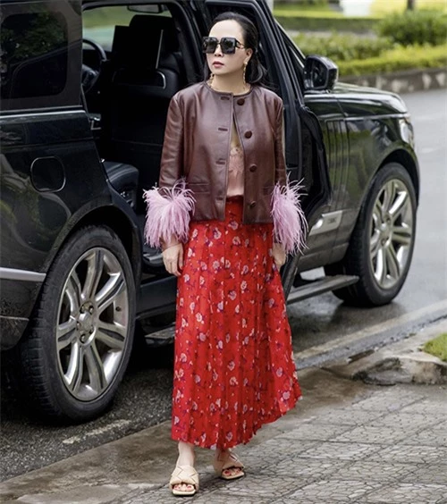 Xuống phố vào những ngày se lạnh cuối tháng 3, Phượng Chanel chọn váy hoa đỏ để diện cùng áo da phối lông vũ, sandal mũi vuông hot trend.