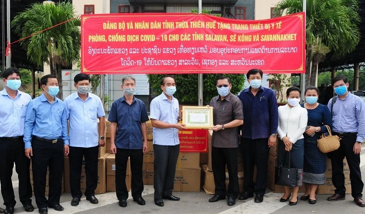 Ông Bùi Thanh Hà, Phó Bí thư Thường trực Tỉnh ủy Thừa Thiên Huế (bên trái) trao tặng vật tư, trang thiết bị y tế cho các tỉnh nước bạn để phòng, chống dịch Covid-19