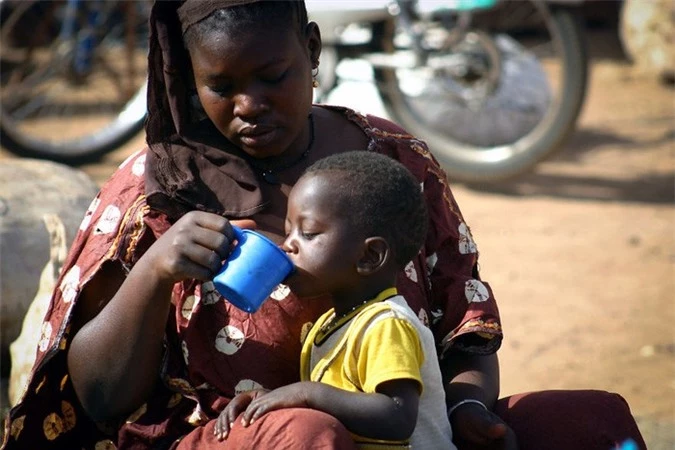 Bà mẹ ở Mali cẩn thận cho cậu con trai nhỏ uống nước.