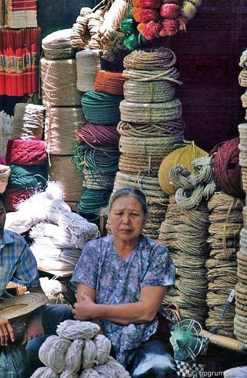 Một bà cụ đang ngồi bán các loại dây thừng