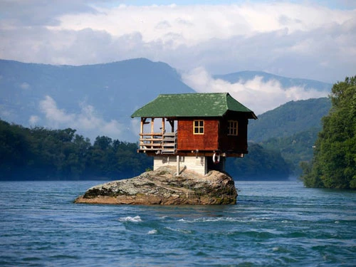 Một ngôi nhà nhỏ được xây trên một tảng đá giữa lòng sông Drina, đoạn chảy qua thị trấn Bajina Basta, Serbia vào năm 1968. Dù bị hư hỏng nhiều lần, ngôi nhà này vẫn luôn được sửa chữa kịp thời. Ảnh: Reuters.