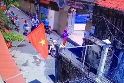 Hình ảnh người phụ nữ đứng chụp ảnh cho bé gái tại cổng trường Tiểu học Quang Trung được camera an ninh nhà dân ghi lại.