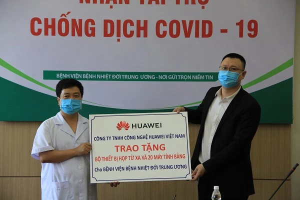 Ông Ma Yunhui, Phó tổng giám đốc Công ty TNHH Công nghệ Huawei Việt Nam (phải), đại diện công ty, trao tặng Bộ thiết bị giải pháp hội nghị truyền hình và 20 máy tính bảng cho ông Lê Văn Dụng, Phó Giám đốc Bệnh viện Bệnh Nhiệt đới Trung ương, đại diện bệnh viện.