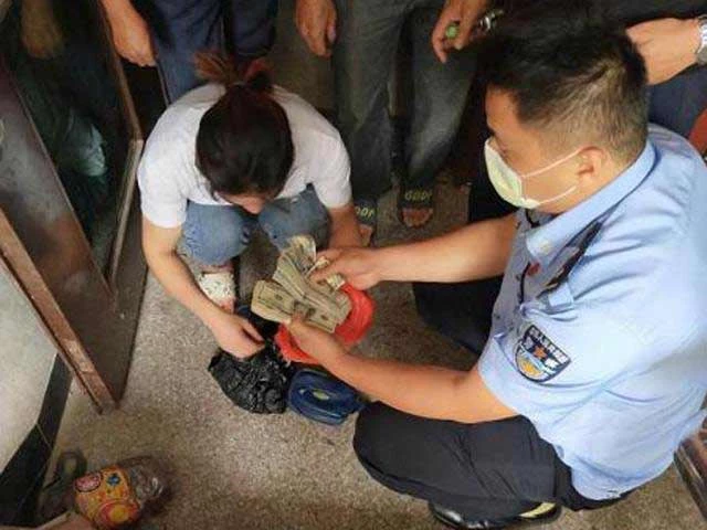 Cảnh sát trả lại cho ông Chen số tiền đã giấu trên trần nhà tắm.