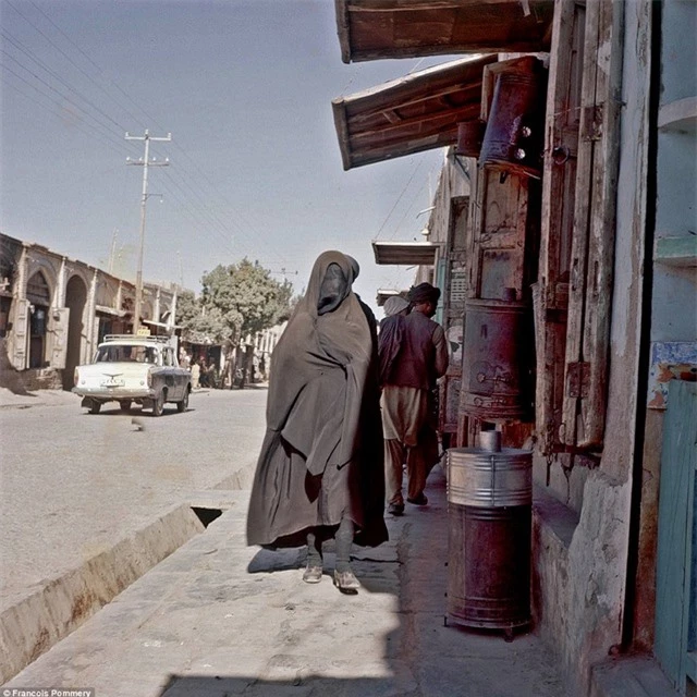 Một người phụ nữ trùm kín trang phục đen đi trên đường ở Heart. Ảnh chụp năm 1974.