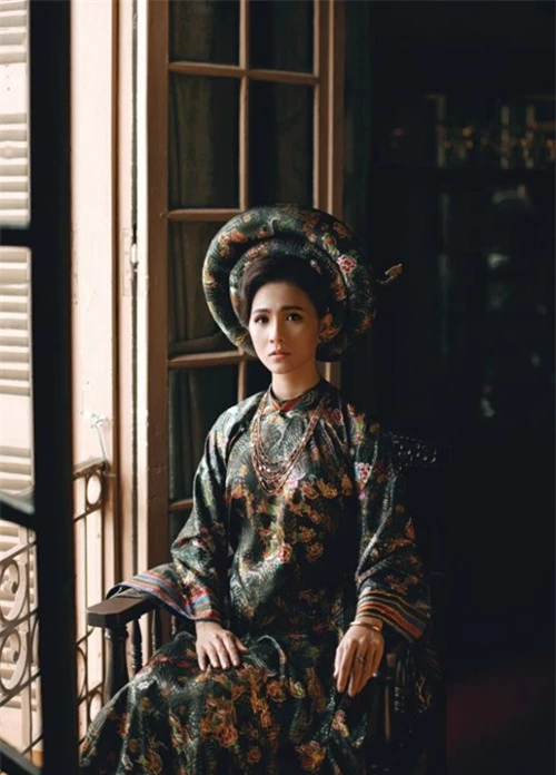 Thùy Trang diện áo dài phong cách cung đình của nhà thiết kế Việt Hùng, tạo dáng trong khung cảnh xưa cũ.