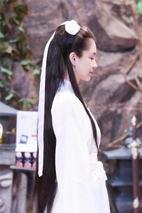 Mái tóc dài chải gọn với dải lụa trắng của cô gợi nhớ tới tạo hình Tiểu Long Nữ của Lý Nhược Đồng trong phimThần điêu đại hiệpbản năm 1995 và của Lưu Diệc Phi trong bản phim năm 2006.