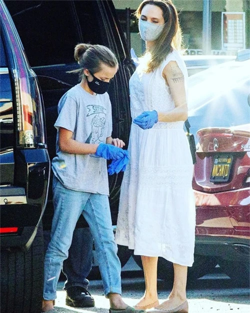 Sau khi xuống xe, Jolie và cô con gái Vivienne cùng đeo găng tay và khẩu trang. Dịch Covid-19 bùng phát mạnh trở lại tại Mỹ khiến người dân ra đường cẩn trọng hơn.