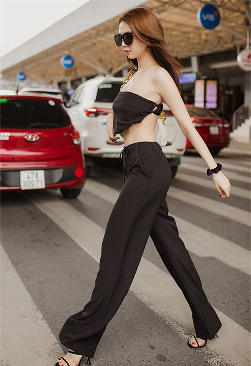 Nữ người mẫu gây chú ý với kiểu áo crop-top hở vai, eo và cả lưng trần. Bộ cánh ton-sur-ton đen làm nổi bật làn da trắng mịn của cô.