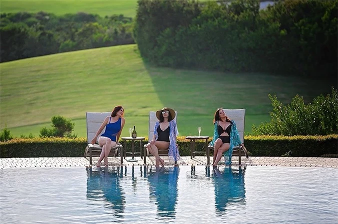 Resort họ ở phong cảnh tuyệt đẹp. Bộ ba mặc áo tắm ngồi uống rượu, tám chuyện bên hồ bơi.