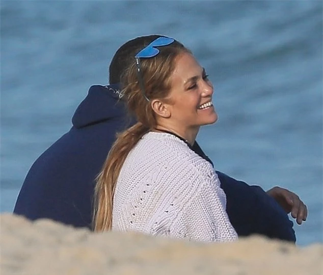 Jennifer Lopez ngồi cạnh Alex Rodriguez trên bãi biển, cười rạng rỡ khi nghe anh trò chuyện.