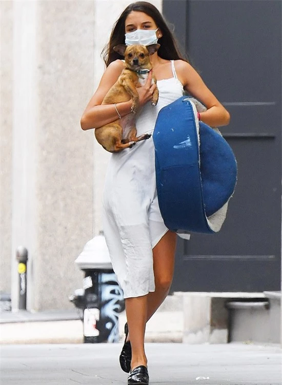 Suri Cruise được trông thấy bế chú cún đi dạo trên đường phố New York hôm 31/7. Cô bé mặc váy hai dây, xỏ giầy da, không còn dấu vết của một nhóc tỳ bé bỏng.