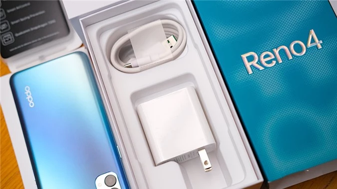 Sau khi bỏ Oppo Reno4 ra chúng ta sẽ thấy cáp sạc USB-C hỗ trợ VOOC Flash Charge 4.0 30W. Dây tai nghe 3.5mm đi kèm. Bộ sạc pin đi kèm trong hộp hỗ trợ đầu ra lên đến 5V 6A và hỗ trợ sạc nhanh VOOC Flash Charge 4.0W.