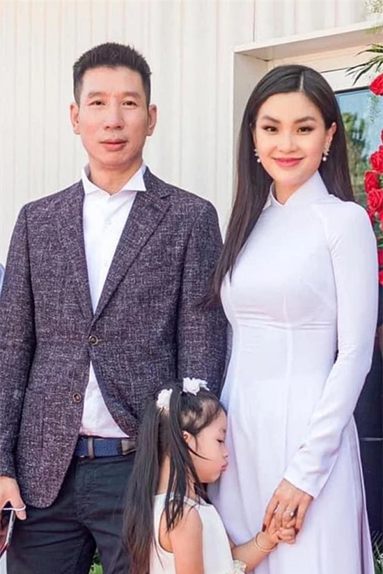Diễm Trang diện áo dài trắng bên cạnh chồng con trong buổi lễ khai trương cách đây ít hôm.