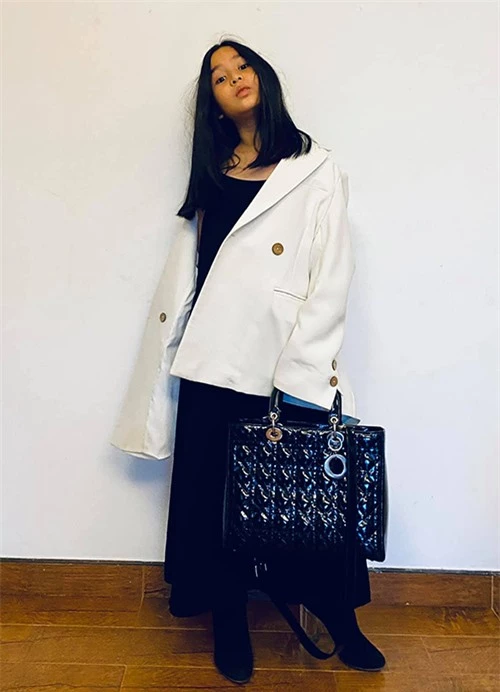 Mina trông như một fashionista cá tính khi diện blazer trắng với váy hai dây đen trùm boot thấp cổ và túi hàng hiệu cùng màu. Các item cùng màu nhưng khác chất liệu tạo nên sự đồng điệu nhưng không nhàm chán trên một set đồ.