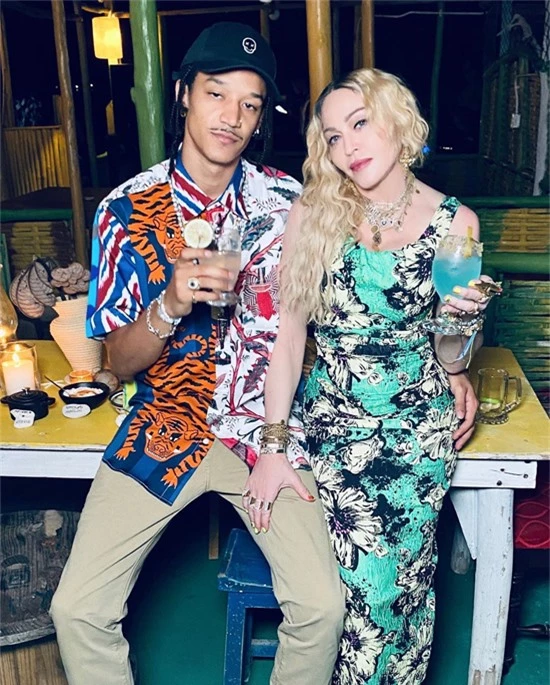Madonna mặc bộ đầm hoa lộng lẫy, ngồi trong vòng tay của chàng vũ công Ahlamalik Williams trong bữa tiệc sinh nhật 62 tuổi của cô ở Jamaica hôm 16/8.