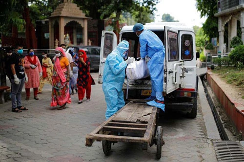 Các nhân viên y tế di chuyển thi thể một người chết vì COVID-19 tại New Delhi, Ấn Độ, hôm 22/8. Ảnh: Reuters.