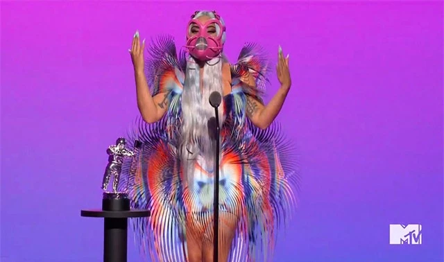 Không lâu sau, ngôi sao 34 tuổi tiếp tục giành giải Màn kết hợp xuất sắc cùng Ariana Grande với ca khúc Rain On Me. Gaga thay trang phục lông vũ gây hiệu ứng thị giác và chiếc mặc nạ màu hồng độc đáo. Dù đeo mặt nạ kín mít, Gaga vẫn có bài phát biểu dài kể về kỷ niệm thu âm cùng Ariana.