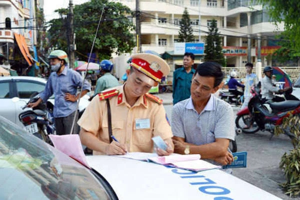 Cảnh sát giao thông đang xử phạt người vi phạm giao thông. Ảnh: Vietnamnet.