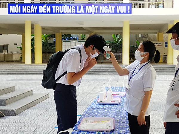 thay khẩu trang y tế mới và đo thân nhiệt trước khi vào phòng thi