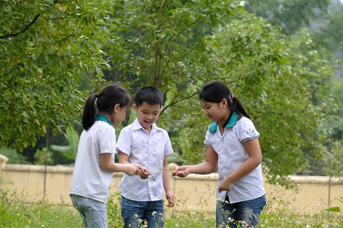 Các em học sinh đến tham quan và vui chơi bên những cây xanh do “Quỹ 1 triệu cây xanh cho Việt Nam” trồng tặng tại khu di tích lịch sử Nà Tu, Bắc Kạn.