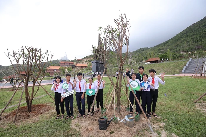 Các em học sinh trồng cây và chụp hình lưu niệm bên những cây xanh vừa trồng trong chương trình “Quỹ 1 triệu cây xanh cho Việt Nam”.