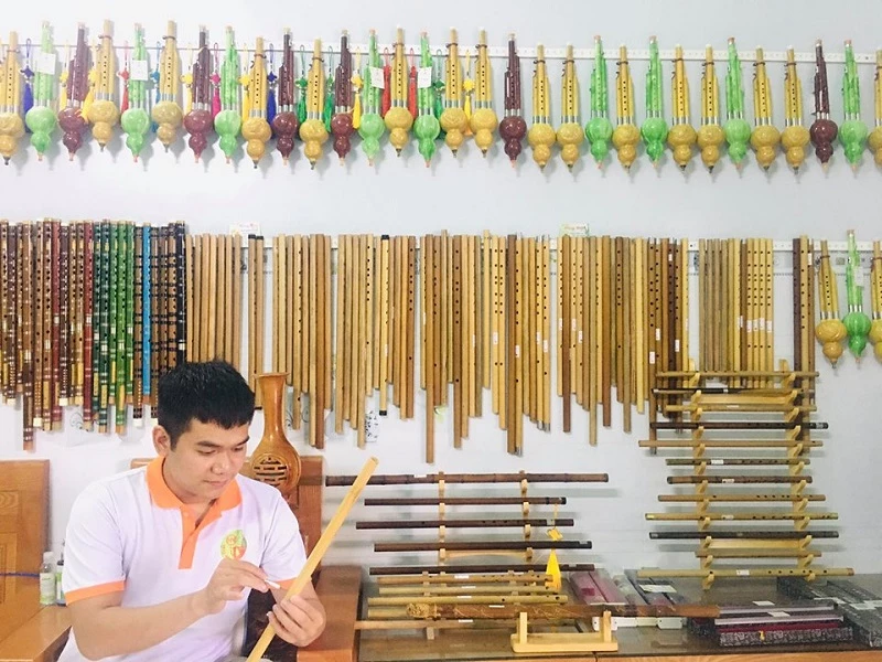 Nguyễn Lê Hoàng Nhân bên cửa hàng sáo trúc của mình. 