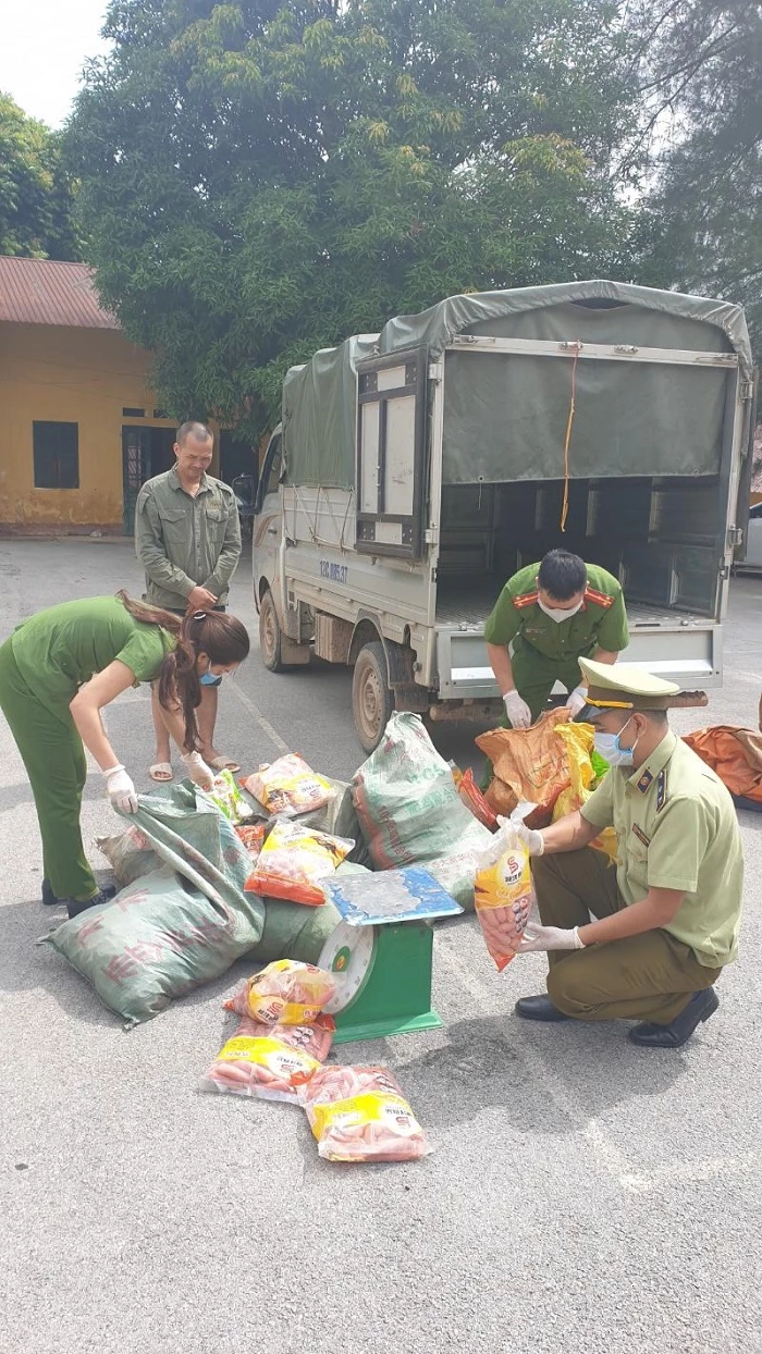 Công chức Đội QLTT số 6 phối hợp với Phòng CSMT - Công an tỉnh kiểm tra số thực phẩm nhập lậu, ảnh: Bình Nguyên.