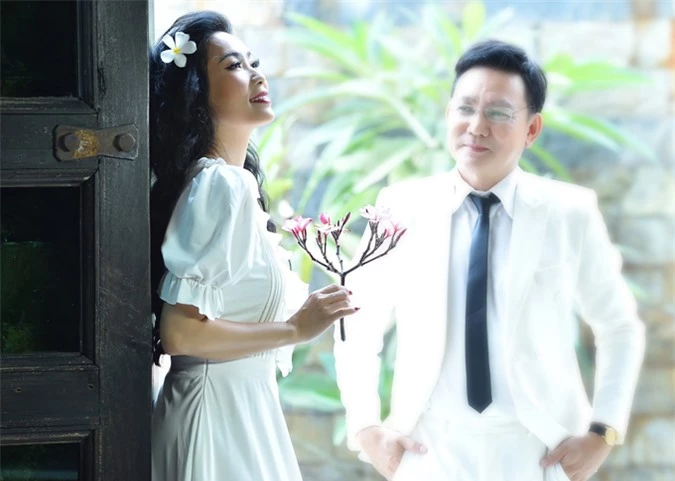 Trịnh Kim Chi điệu đà làm duyên với hoa sứ trong khi ông xã say sưa ngắm cô.