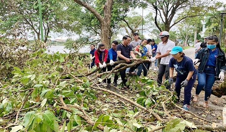 Các lực lượng tập trung thu gom cành cây gãy tại hai bên bờ sông Hương.