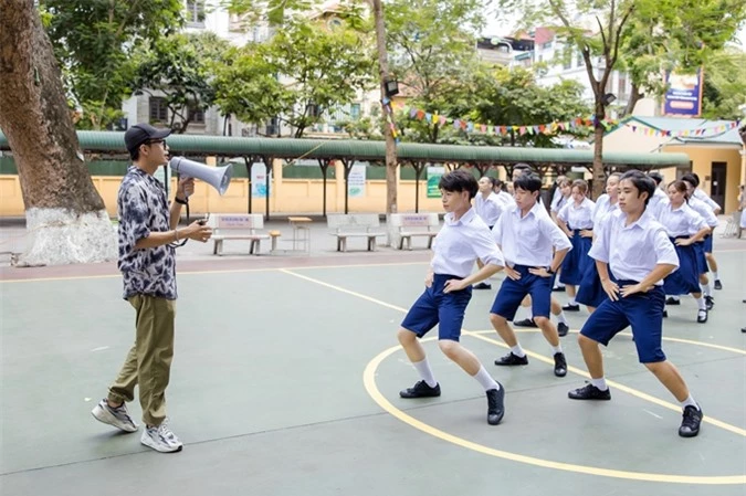 Quang Đăng cầm loa, chỉ đạo phần nhảy của Đức Phúc cùng 60 vũ công tại bối cảnh một trường THPT ở Hà Nội. Quang Đăng khen ngợi Đức Phúc nhảy đẹp và phối hợp ăn ý với dàn vũ công đông đảo.
