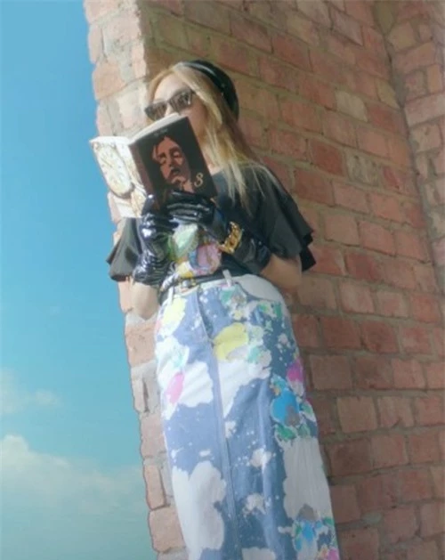 Chân váy jeans mang đủ màu sắc loang lổ của Moschino được nữ ca sĩ phối cùng áo phông họa tiết đồng thương hiệu