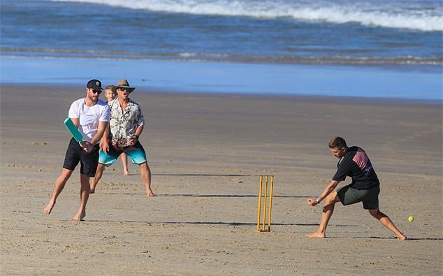 Chris, Liam và anh trai cả Luke Hemsworth (áo hoa) chơi bóng trên bãi biển.