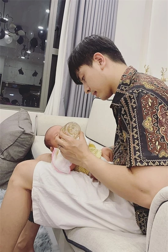 Kin Nguyễn phụ vợ cho con gái bú. Ông bố trẻ chăm con khá thuần thục.