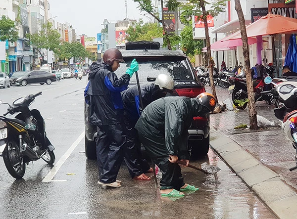 Người dân Đà Nẵng chủ động khơi thông các cửa thu nước xuống cống để giảm thiểu tình trạng ngập úng đô thị do mưa lớn kéo dài