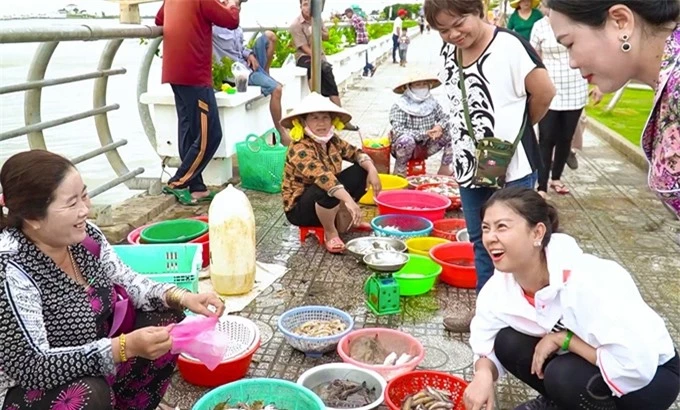 Kim Thư trò chuyện với tiểu thương ở chợ cá.