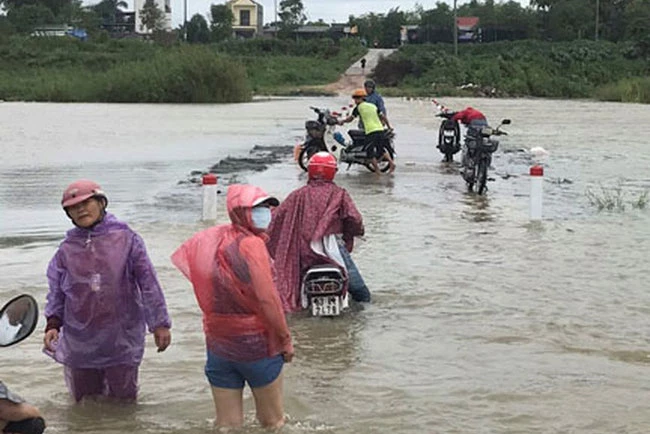 Người dân xã Tịnh An, TP Quảng Ngãi lội qua đoạn sông Trà Khúc bị nước lũ chia cắt chiều 7/10. (Ảnh: Báo điện tử Người lao động)