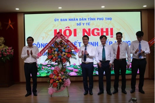 Ông Nguyễn Minh Tường, TUV, Bí thư huyện ủy (bên trái) tặng hoa chúc mừng TTYT Thanh Thủy.