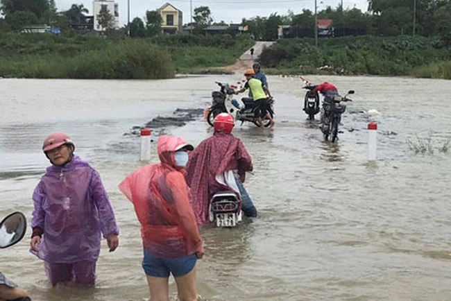 Người dân xã Tịnh An, TP Quảng Ngãi lội qua đoạn sông Trà Khúc bị nước lũ chia cắt. (Ảnh: Báo điện tử Người lao động)
