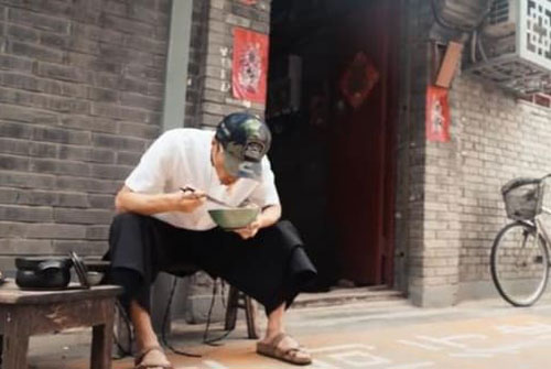 Tạ Đình Phong 40 tuổi ngồi xổm trong ngõ ăn mì, đi dép lê và ngày càng giống ông già