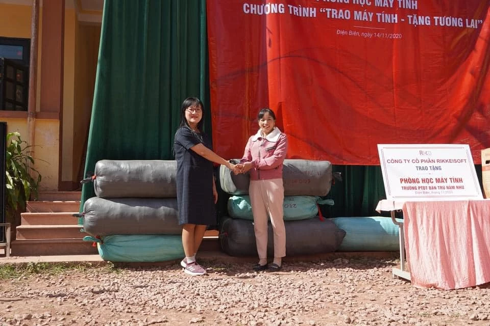 Đại diện Quỹ Tình người Lai Châu (bên trái) trao tặng quà là những chiếc áo ấm, dép, thuốc bổ cho trường tiểu học Nậm Nhừ.