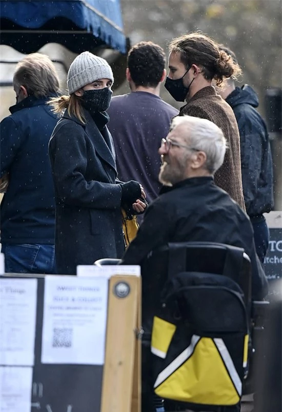 Emma Watson và bạn trai đứng chờ cafe cạnh đồi Primrose ở London. Cặp đôi cẩn thận mặc áo ấm, đeo khẩu trang để tránh dịch bệnh.